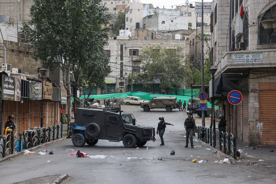 Israeli forces block a road in the occupied West Bank city of Hebron after closing Palestinian access to the city center on October 9, 2025.