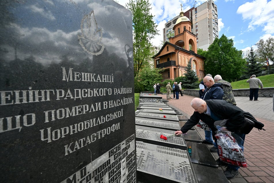 A liquidator lays flowers to the Chernobyl memorial in Kyiv, Ukraine, next to the names of his late friends on April 26, 2025.