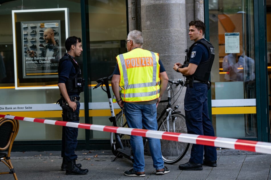 Polizisten stehen vor einer Bank unweit des Kurfürstendamm.