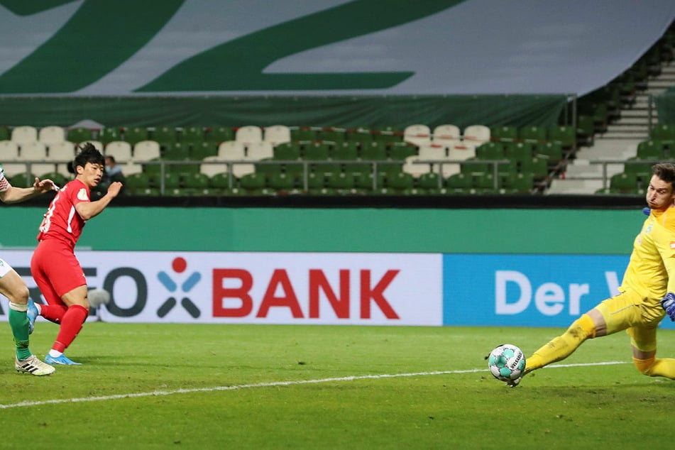 Da ist das Ding! Der eingewechselte Hee-chan Hwang (l.) schiebt den Ball an Jiri Pavlenka (r.) vorbei zum 1:0 für RB Leipzig ins Tor.