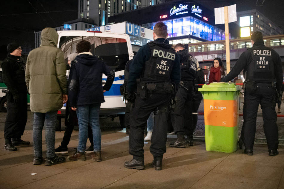 Polizisten und Passanten stehen an Silvester 2019 an einem Kontrollpunkt am Alexanderplatz. (Archivbild)