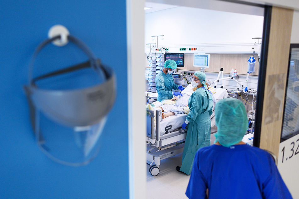 Intensivpfleger sind in der Corona-Intensivstation des Universitätsklinikums Dresden mit der Versorgung von Patienten beschäftigt.