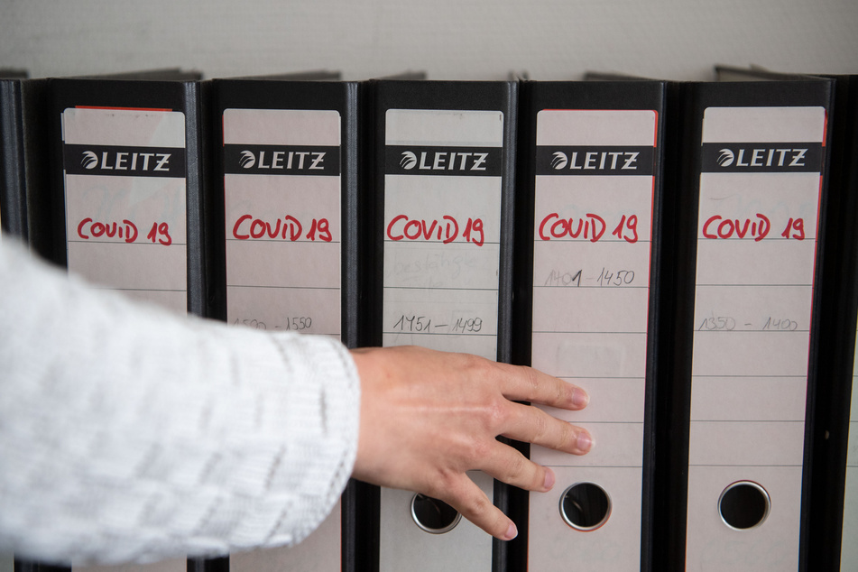Die Koordinatorin des Kontaktpersonenmanagement im Gesundheitsamt des Landkreises Esslingen schiebt einen Ordner in eine Regalreihe zurück.
