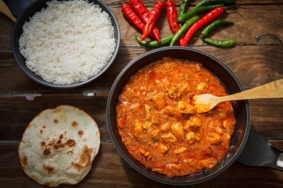 Zu Butter Chicken passen gewürzter Basmatireis und Knoblauch-Naan.