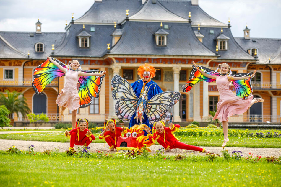 Rainer König (68, Mitte) fiebert mit den Schmetterlingen Editha (12, l.) und Malin (12) sowie den Drachen Selina (9, v.l.), Mathilda (9) und Karla (11) von den Tanzklassen des Puck e.V und der Paluccaschule dem Elbhangfest entgegen.
