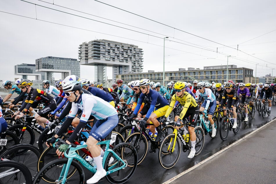 Das Feld der Profiteams rollte zum Start des Radrennens "Rund um Köln" 2026 auf der Severinsbrücke hinter dem Führungsfahrzeug. (Archivfoto)
