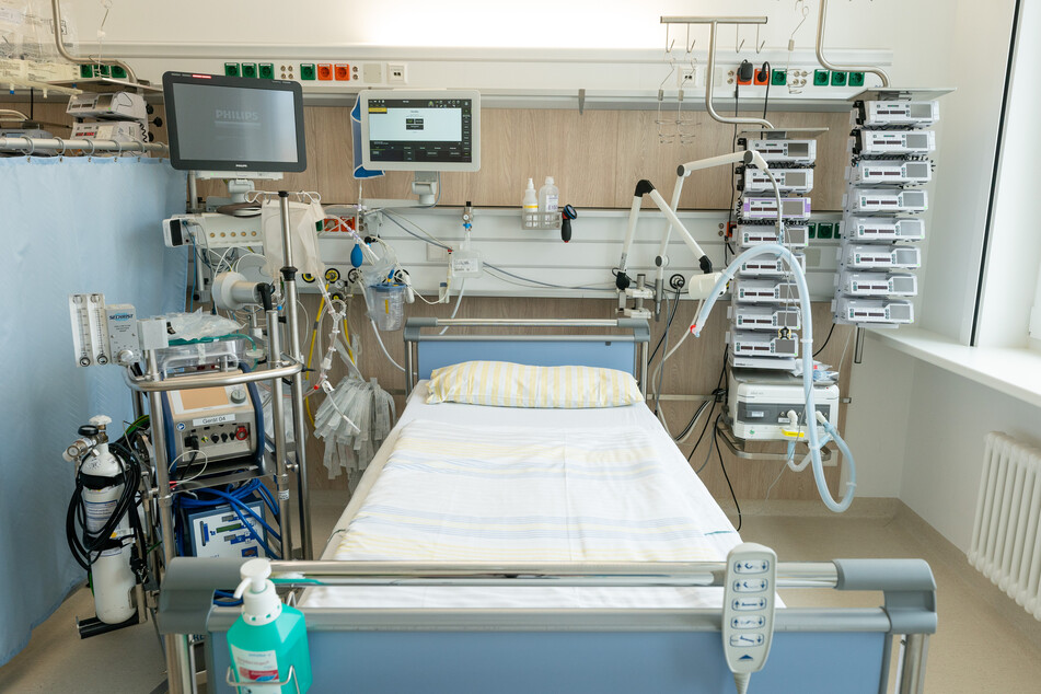 Ein Intensivbett auf einer Intensivstation der Uniklinik Dresden. Links neben dem Bett steht eine Herz-Lungen-Maschine, oben befinden sich die Überwachungsmonitore für die Vitalfunktionen. Rechts neben dem Bett steht ein Beatmungsgerät und Infusionstechnik.
