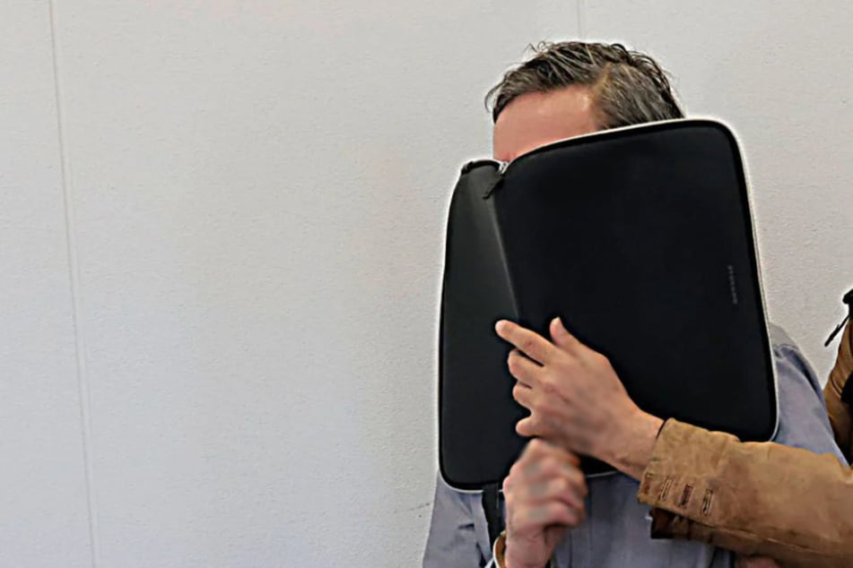 Der Angeklagte (46) verbarg am Montag sein Gesicht hinter einer Mappe.