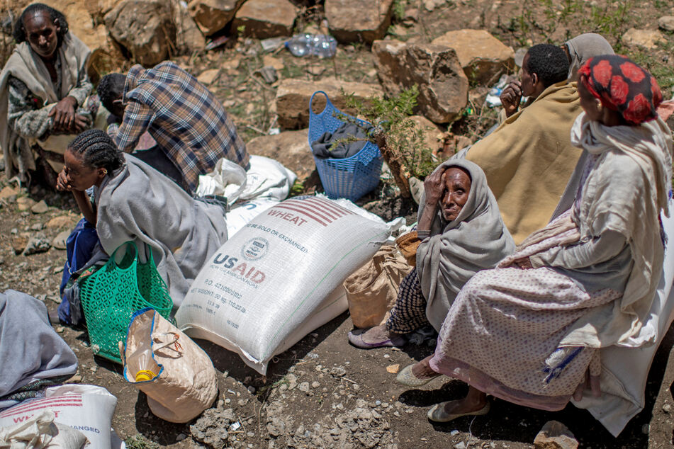 Eine ältere äthiopische Frau sitzt neben einem Sack Weizen, der zuvor in der Region Tigray im Norden Äthiopiens verteilt wurde.
