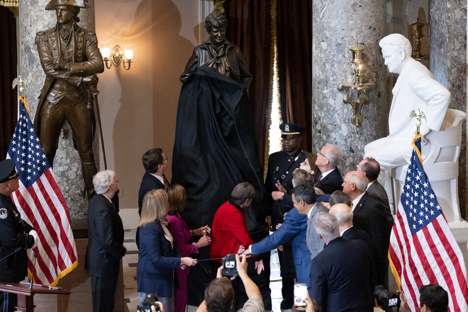 Members of Congress and guests applaud as a statue of aviator Amelia Earhart, the first woman to fly solo across the Atlantic Ocean, is unveiled during a ceremony in Statuary Hall at the US Capitol in Washington, DC, on July 27, 2022.