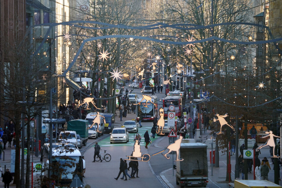 Passanten erledigen Einkäufe in der weihnachtlich geschmückten Innenstadt. Nur noch maximal zehn Personen dürfen in Hamburg privat zusammentreffen.