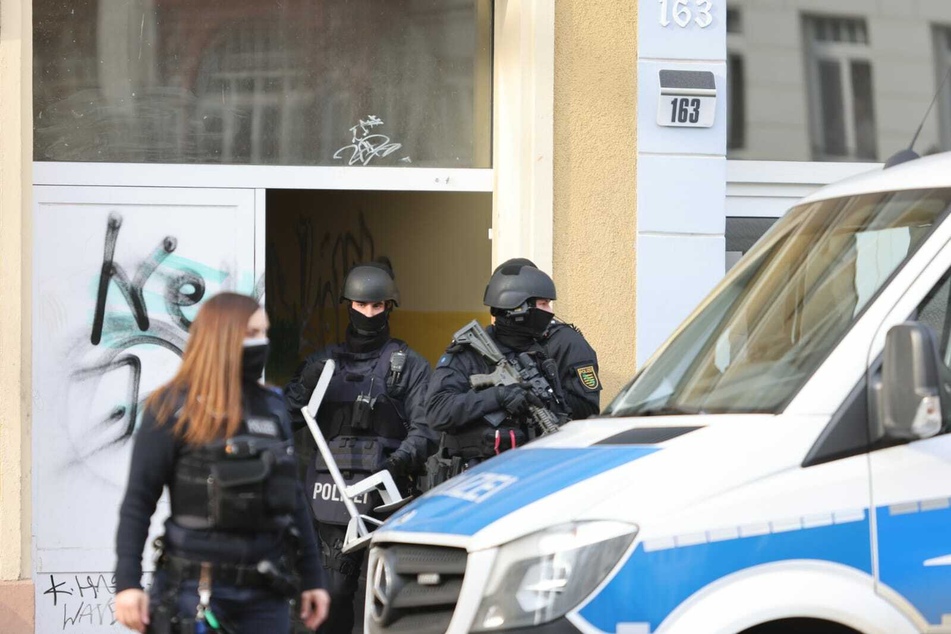 Einsatzkräfte des SEK verlassen ein Haus in der Wurzener Straße. Laut Polizei begleiten diese die anberaumten Durchsuchungen.