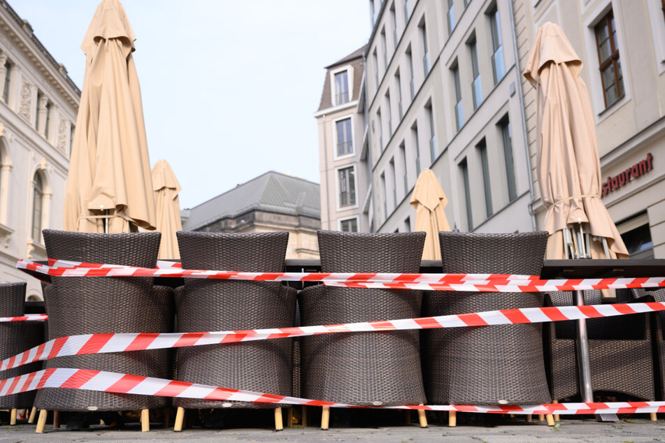 Ein Absperrband umgibt Tische und Stühle vor einem Restaurant auf dem Neumarkt. Grundsätzlich wird der Lockdown bis zum 28. März verlängert, allerdings mit Öffnungsmöglichkeiten je nach Infektionslage.