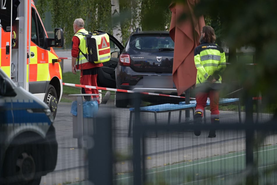 Rettungskräfte an dem Dacia der Unfallfahrerin. Warum die Frau auf den Schulhof fuhr, ist aktuell noch unklar.