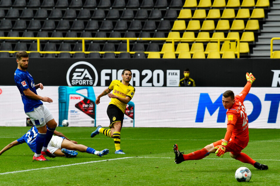 BVB-Flügelflitzer Raphael Guerreiro (Z.v.r.) überwindet Markus Schubert (r.) mit seinem platzierten Schuss und erzielt das 2:0 für Dortmund. Der S04-Keeper hatte das Tor mit seinem Fehlpass eingeleitet.