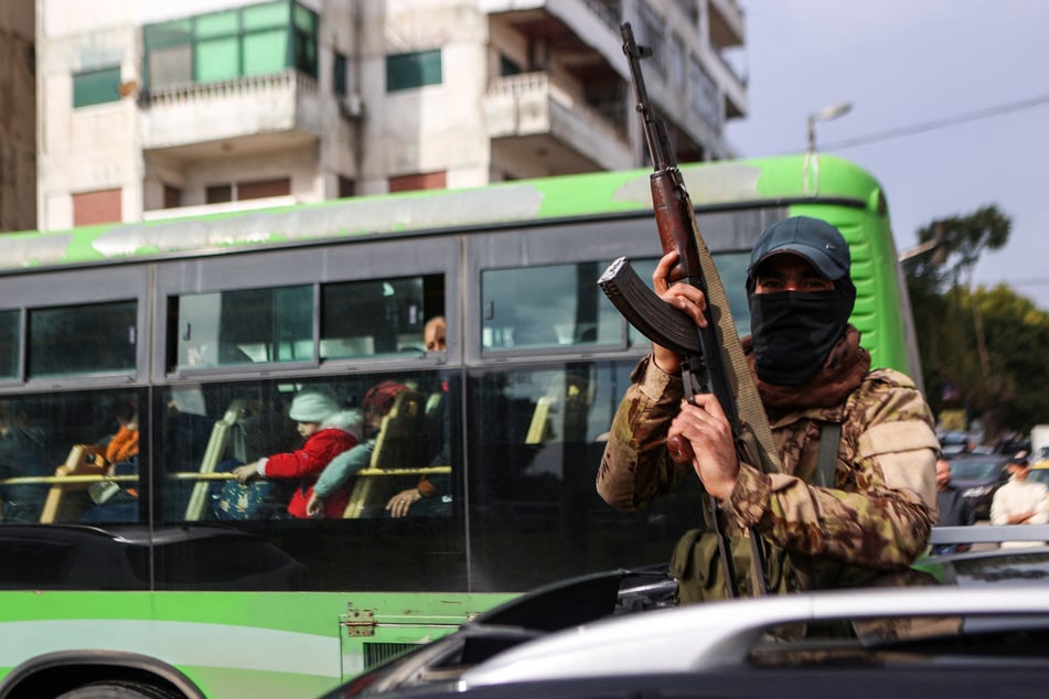 A fighter affiliated with Syria's new administration gestures with his rifle in Syria's western coastal city of Latakia on December 26, 2024. Syria's new authorities launched an operation in a stronghold of ousted president Bashar al-Assad on Thursday, with a war monitor saying three gunmen affiliated with the former government were killed.