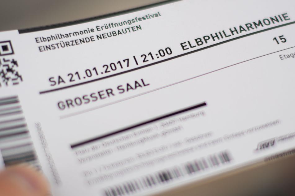 Eine Person hält eine Eintrittskarte für die Elbphilarmonie.