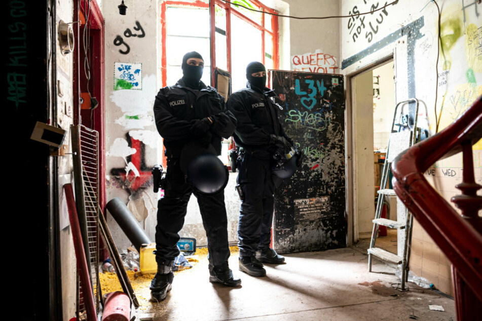 Zwei Polizisten stehen nach der Räumung im Treppenhaus des ehemals besetzten Hauses "Liebig 34".