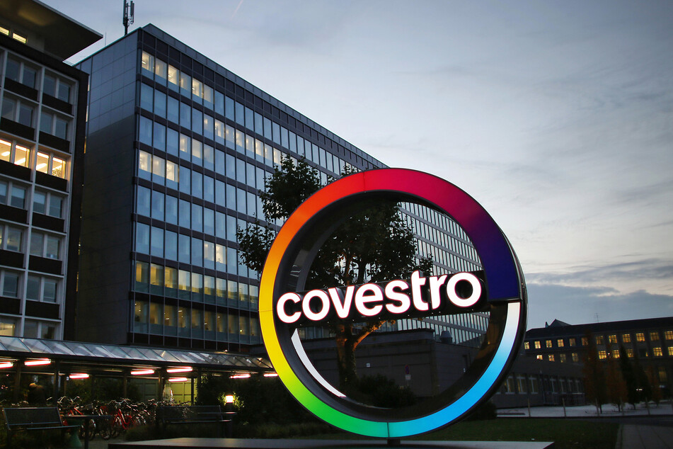 Das Logo des Kunststoffkonzerns Covestro leuchtet vor der Unternehmenszentrale am Chempark in Leverkusen.