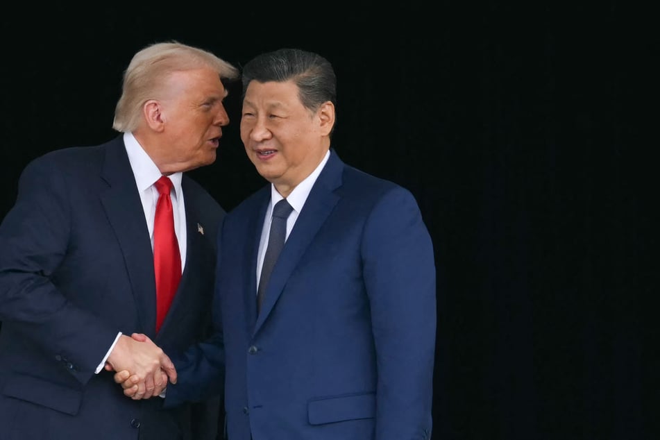 US President Donald Trump (l.) and China's President Xi Jinping shake hands as they leave after their talks at the Gimhae Air Base on October 30, 2025.