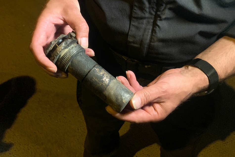 Ein Munitionsexperte hält den Zünder der 250-Pfund-Bombe in den Händen.