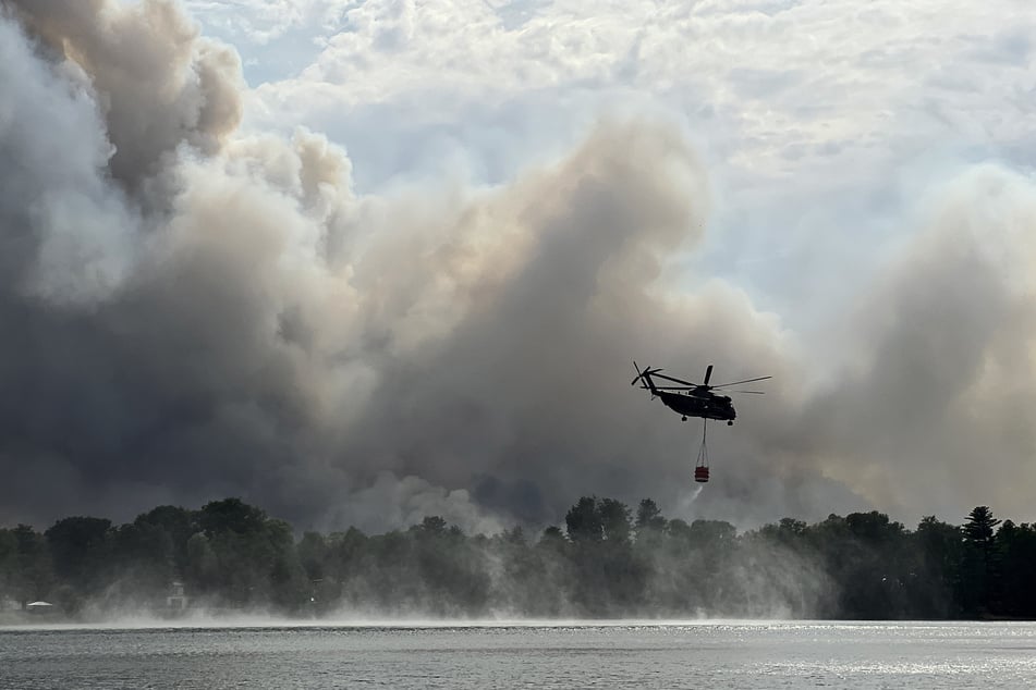 Bei einem Waldbrand überfliegen die Helikopter die brennende Fläche mit sogenannten "Bambi Buckets", die vorher mit Wasser aufgefüllt wurden. (Symbolbild)
