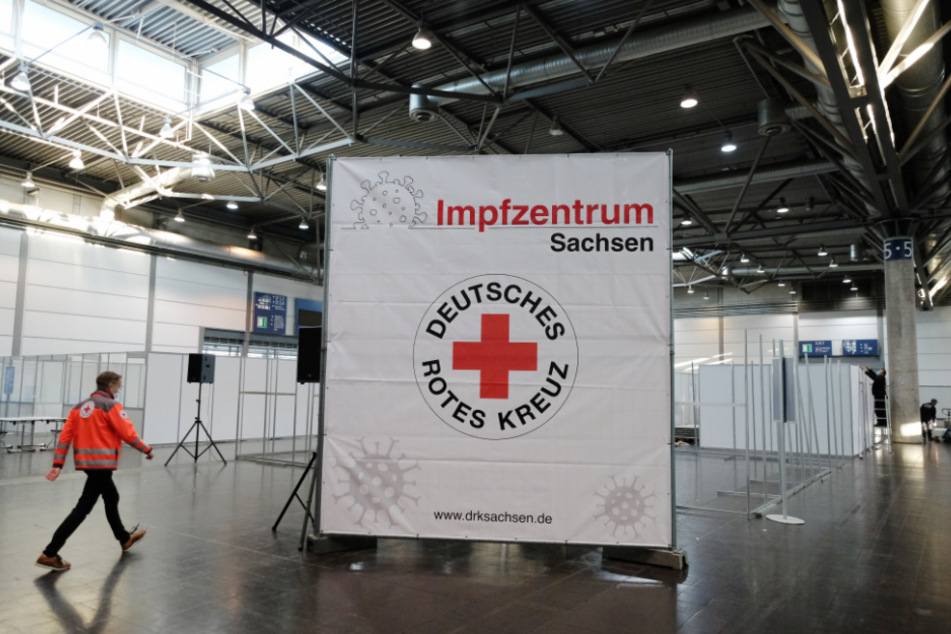 Ein Mitarbeiter des Deutschen Roten Kreuzes geht durch eine Halle der Leipziger Messe. Dort entsteht ein künftiges Impfzentrum zur Bekämpfung der Corona-Pandemie.