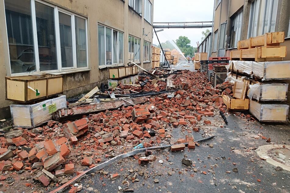 Trümmerteile liegen in einer Gasse auf dem Firmengelände bei Wunsiedel.