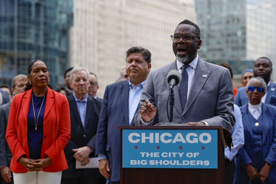 Chicago Mayor Brandon Johnson (c.) signed an executive order barring local police from collaborating with military personnel or immigration enforcement.