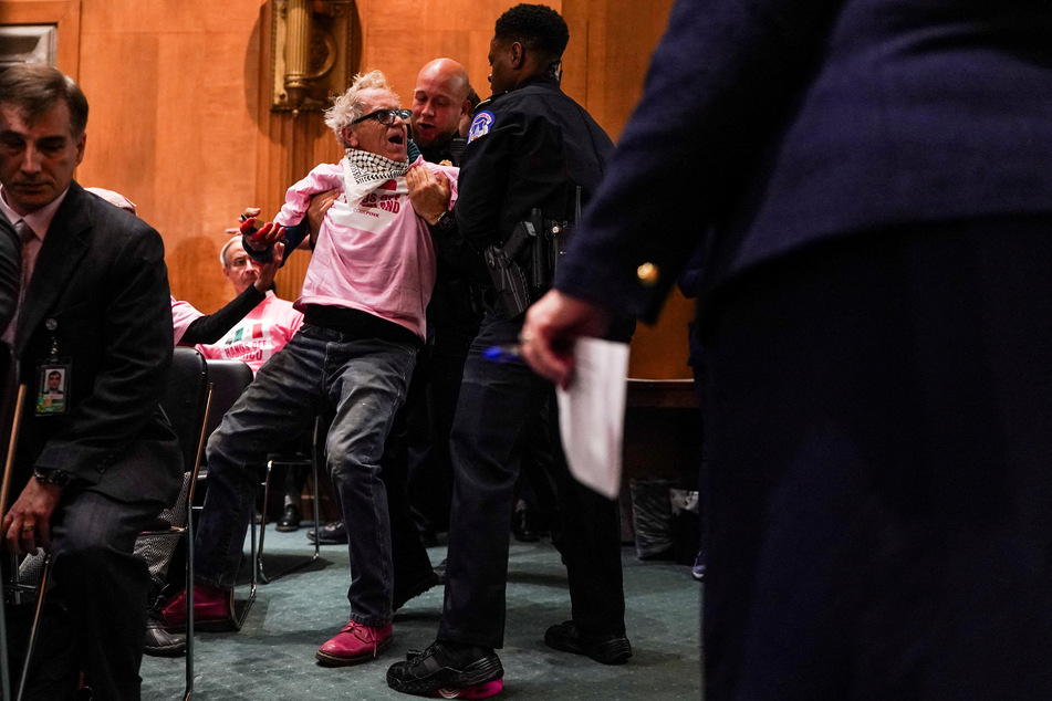 Security personnel forcibly remove an activist as Marco Rubio testifies during his Senate Foreign Relations Committee confirmation hearing.