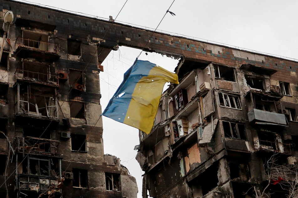 A torn Ukrainian flag hangs on a wire in front a destroyed apartment building in the southern port city of Mariupol.