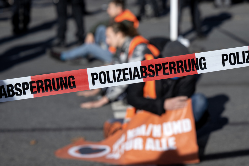 Die Polizei hat eine Protestaktion auf einer Straße in München abgesperrt. Die Aktivisten fürchten sich eher vor Autofahrern, als vor der Löseaktion.