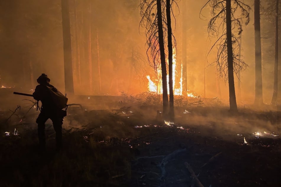 Einsatzkräfte versuchen, die Flammen in Schach zu halten.
