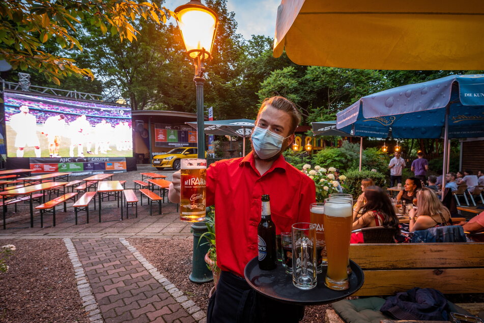 Kellner Felix Hähnel serviert den Gästen beim Public Viewing im Miramar kalte Getränke.
