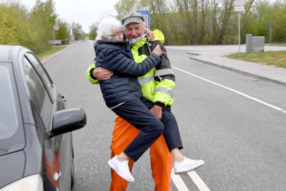 Inga Rasmussen aus Dänemark (85) wird von Karsten Tüchsen Hansen (89) aus Nordfriesland bei ihrem täglchen Treffen an der deutsch-dänischen Grenze hochgehoben.