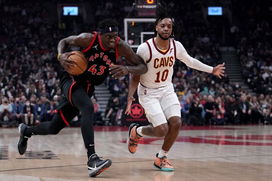 Toronto Raptors forward Pascal Siakam (l.) drives past Cleveland Cavaliers guard Tim Frazier.