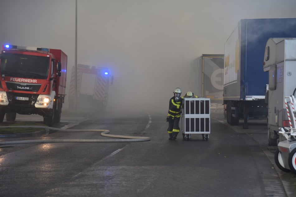 Mit Radladern wird der verschmolzene Metallschrott auseinandergezogen, um das Feuer unter Kontrolle zu bringen.
