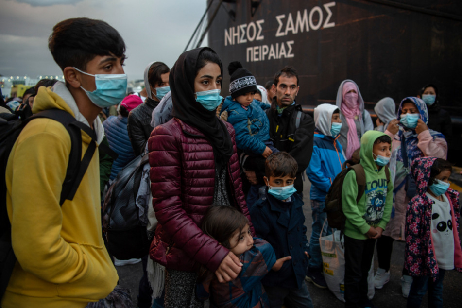 Menschen aus dem Flüchtlingslager Moria, die mit einem Schiff von der Insel Lesbos gekommen waren, stehen nach ihrer Ankunft im Hafen von Piräus bei Athen.