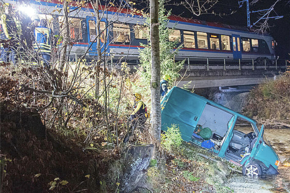 VW-Bus wird von Zug mitgeschleift und landet in Fluss: Fahrer schwer verletzt