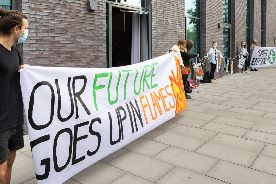 Aktivisten der Bewegung "Fridays for future" machen vor dem Veranstaltungsort auf den Klimaschutz aufmerksam.