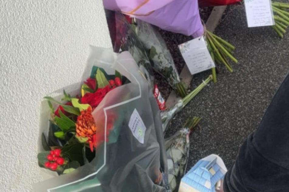 Mehrere Freunde legten Blumen vor das 17-stöckige Wohnhaus.