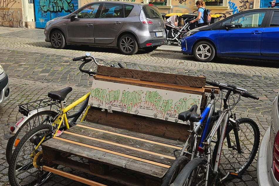 Die Botschaft ist eindeutig: "Unter dem Asphalt liegen die Gärten" steht auf der einen Seite der Blockadebank - "Hier könnte ein halber SUV stehen" auf der anderen.