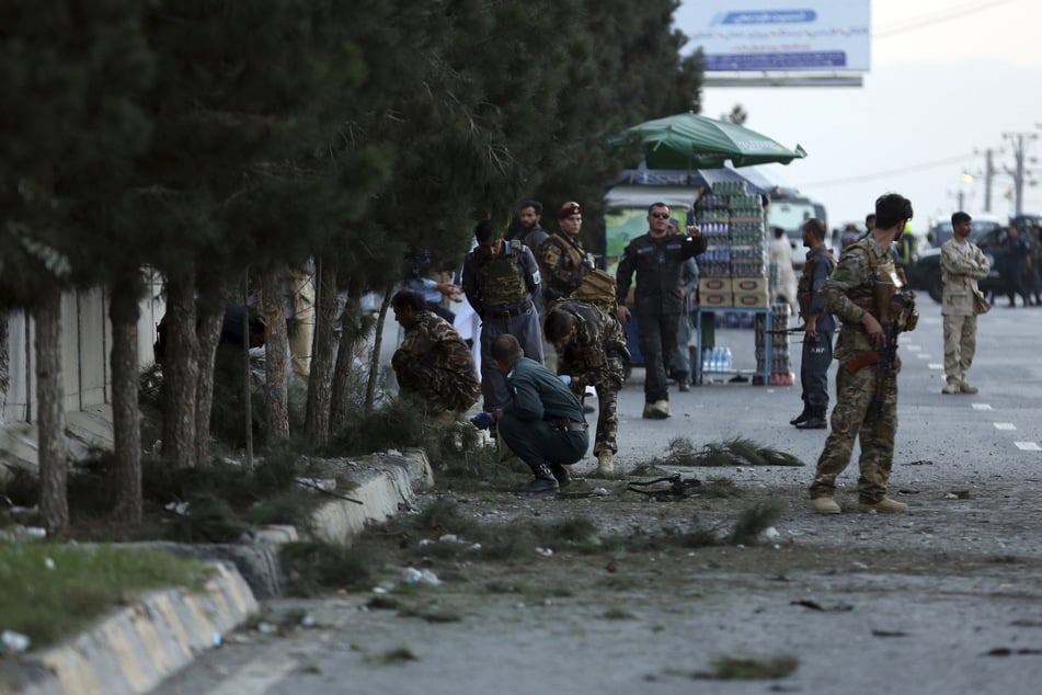 Afghanistan, Kabul: Sicherheitskräfte untersuchen an einer Straße den Ort einer Explosion.