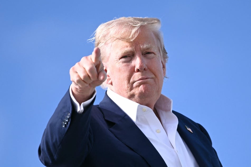 President Donald Trump points as he boards Air Force One at RAF Lossiemouth, north-east Scotland on July 29, 2025