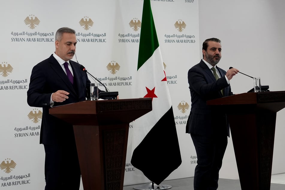 Der syrische Außenminister Asaad al-Schaibani (38, r) und der türkische Außenminister Hakan Fidan (57) nehmen an einer gemeinsamen Pressekonferenz in Damaskus teil.