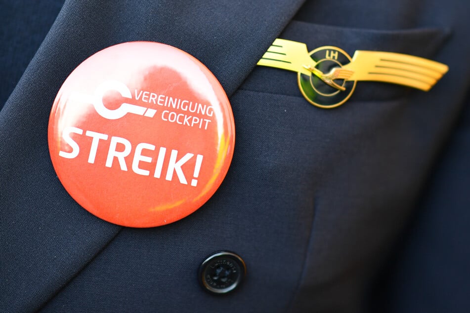 Ein Lufthansa-Pilot trägt bei einer Kundgebung der Pilotengewerkschaft Vereinigung Cockpit einen Button mit der Aufschrift "Streik" auf seiner Uniform.