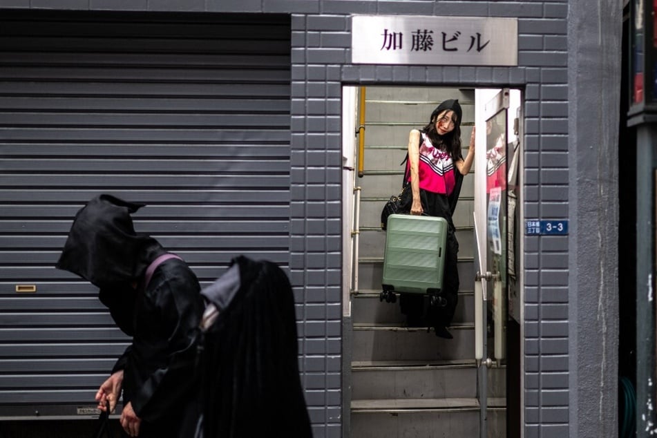 Actors walk to Tokyo station before boarding a bullet train to perform for passengers during the Zombie Shinkansen event on a trip to Osaka, ahead of Halloween on October 19, 2024.