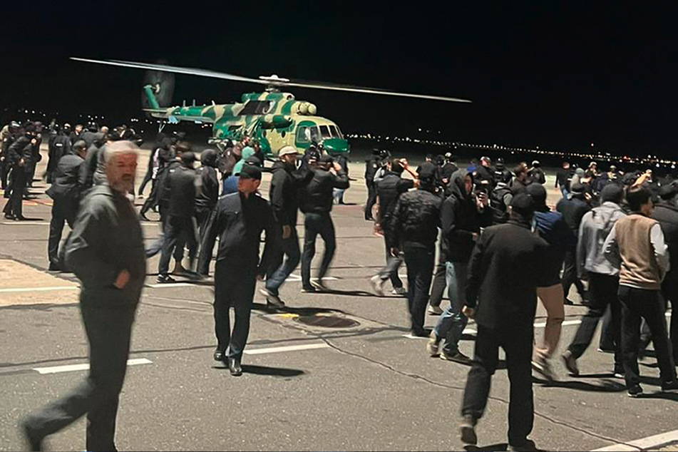 Menschen laufen und rufen antisemitische Parolen auf einem Flugfeld des Flughafens in Machatschkala, Russland.