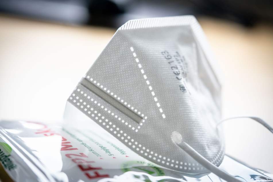 Eine FFP2-Maske liegt auf einem Tisch auf der Verkaufsverpackung.
