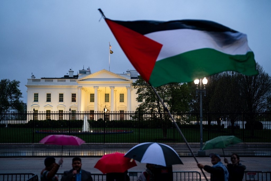 Demonstrators wave a Palestinian flag and call for a ceasefire in Gaza during a protest outside the White House.